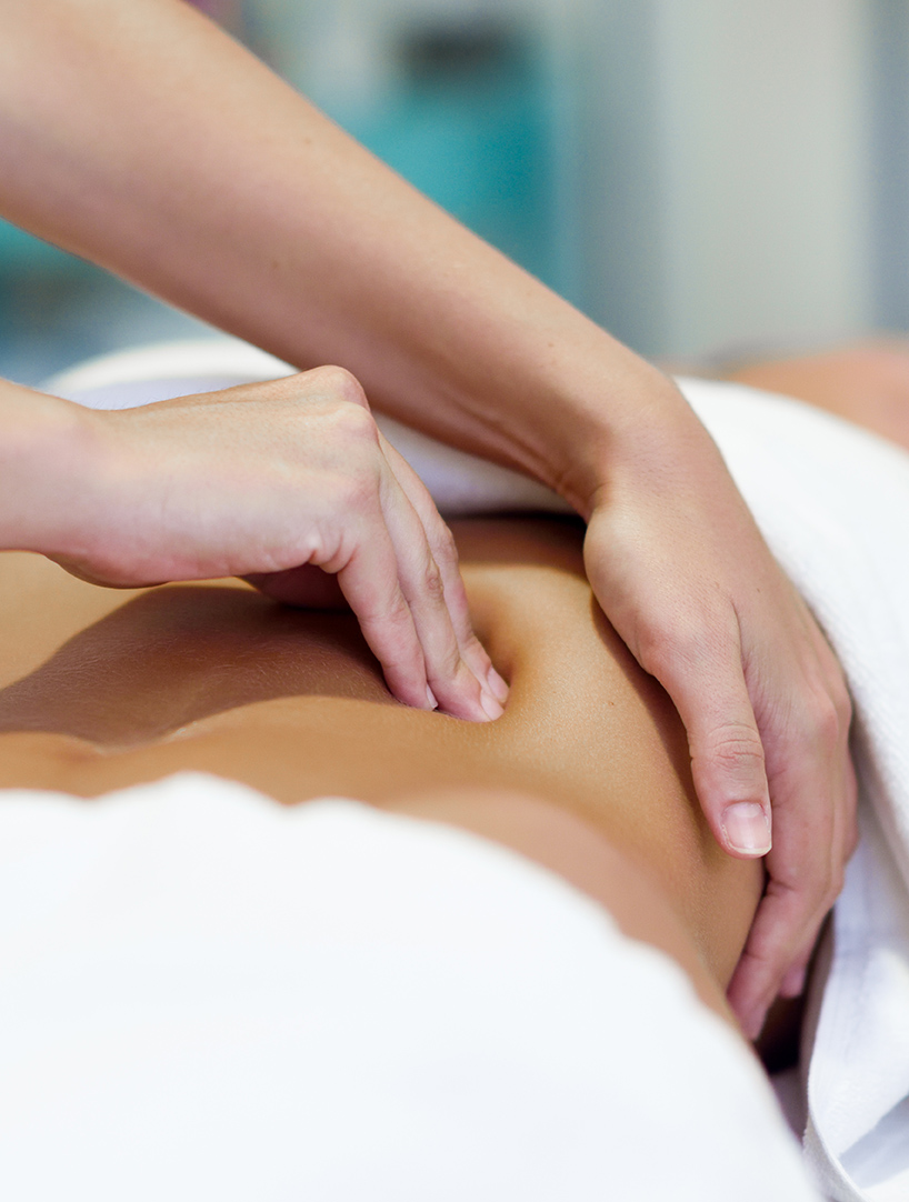 woman having abdomen massage by professional osteopathy therapist - Guardian Clinic